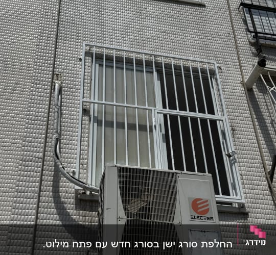 יחידת מיזוג אוויר מותקנת על קיר עם סורגים